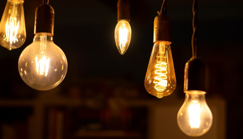 Retro LED light bulbs hanging on a dark background in interior. Electricity, Vintage